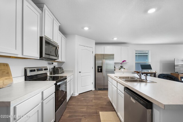 2035 Garrison Way, Green Cove Springs, FL 32043 - kitchen with white cabinetry, stainless steel appliances, dark hardwood / wood-style floors, and a kitchen island with sink