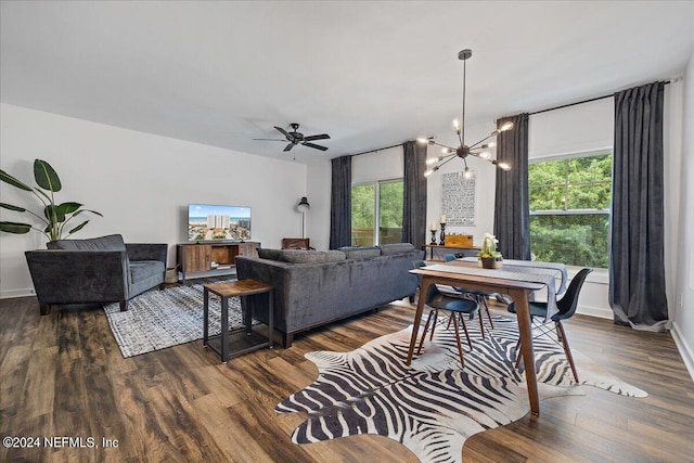 living room with ceiling fan with notable chandelier and dark wood-type flooring