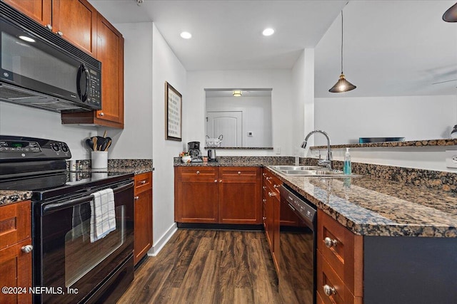 kitchen featuring sink, dark wood-type flooring, dark stone countertops, pendant lighting, and black appliances