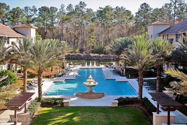 view of swimming pool with a lawn, a patio area, and a water view