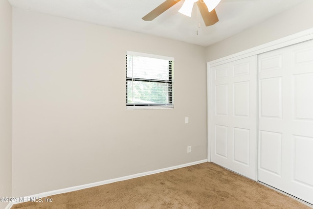 unfurnished bedroom with ceiling fan, a closet, and light carpet