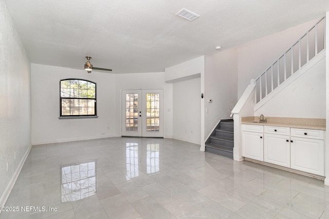 unfurnished room with ceiling fan, french doors, a textured ceiling, and sink