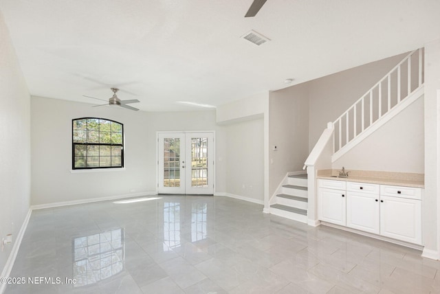 interior space with baseboards, stairs, and ceiling fan