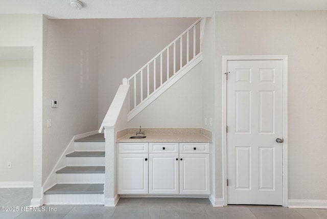 stairway with tile patterned floors and baseboards