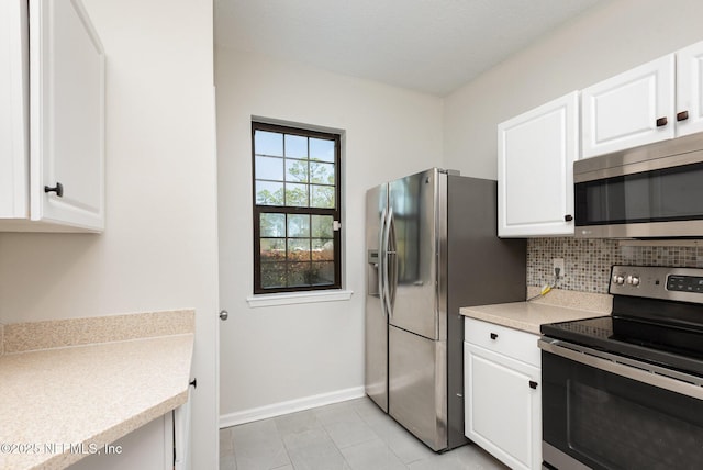 kitchen featuring tasteful backsplash, baseboards, light countertops, appliances with stainless steel finishes, and white cabinets