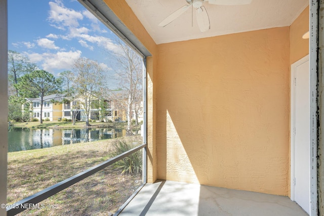 sunroom featuring a water view and ceiling fan