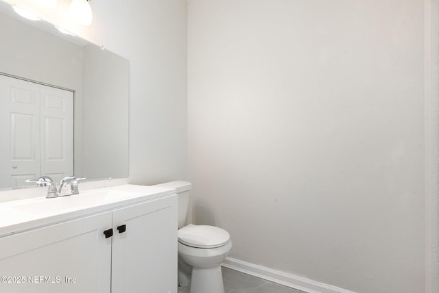 bathroom with baseboards, toilet, and vanity