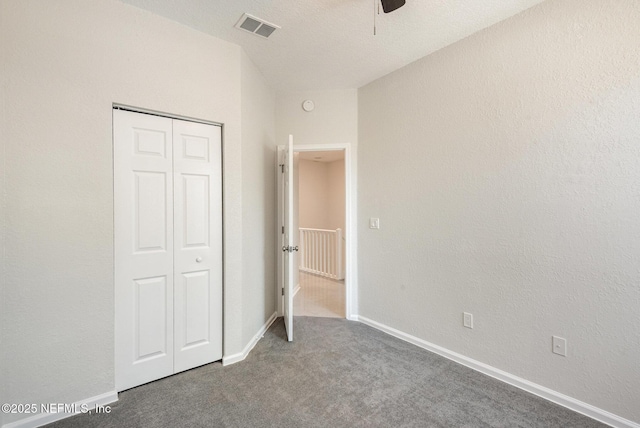 unfurnished bedroom featuring carpet flooring, baseboards, visible vents, and a closet