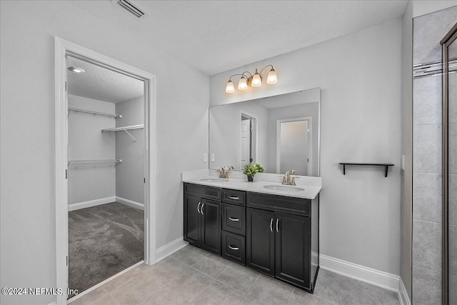 bathroom with vanity, tile patterned flooring, and a textured ceiling