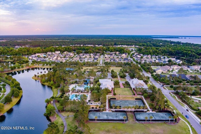 aerial view at dusk featuring a water view