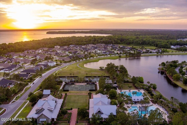 aerial view at dusk featuring a water view