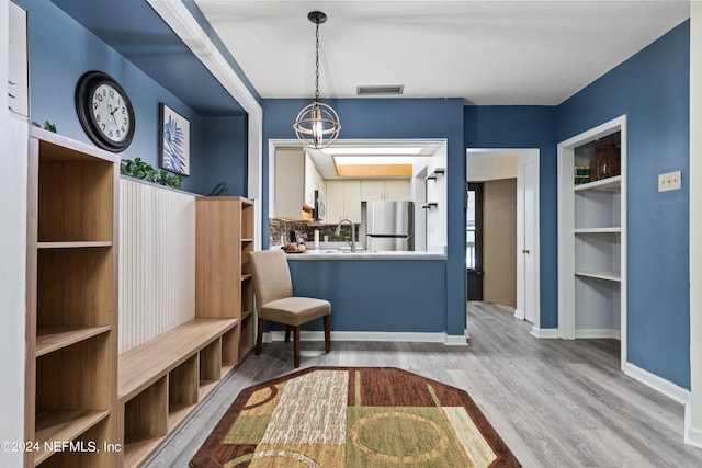 mudroom with a chandelier, light hardwood / wood-style floors, and sink