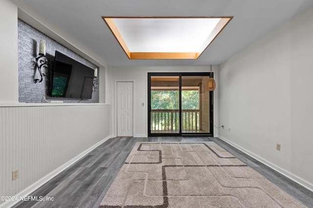 interior space with hardwood / wood-style flooring and wood walls