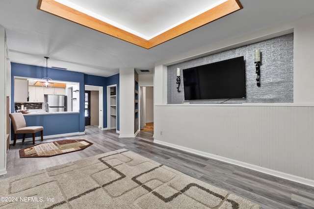 unfurnished living room featuring wood walls and dark hardwood / wood-style flooring