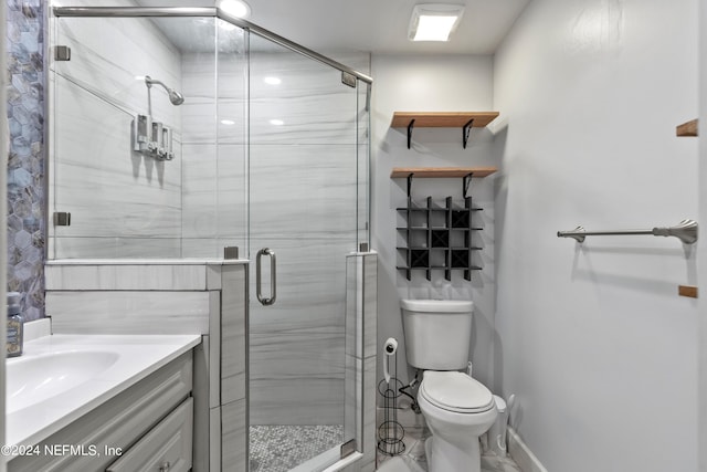 bathroom with vanity, toilet, and a shower with shower door