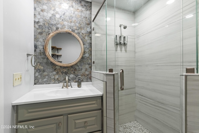 bathroom featuring decorative backsplash, vanity, and a shower with shower door