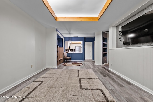 unfurnished living room with a tray ceiling and wood-type flooring