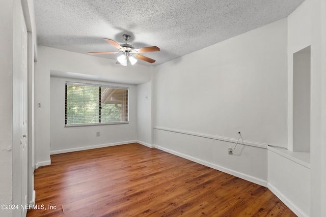 empty room featuring ceiling fan, a textured ceiling, and hardwood / wood-style flooring