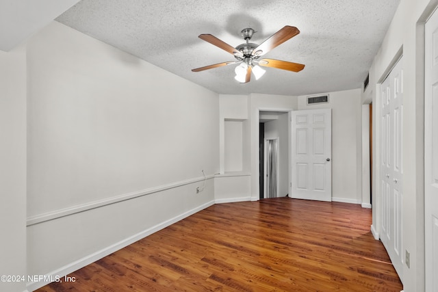 unfurnished bedroom featuring a textured ceiling, ceiling fan, and dark wood-type flooring