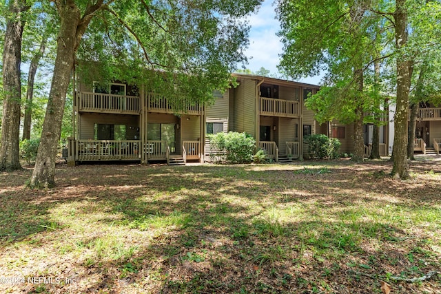 rear view of house featuring a lawn