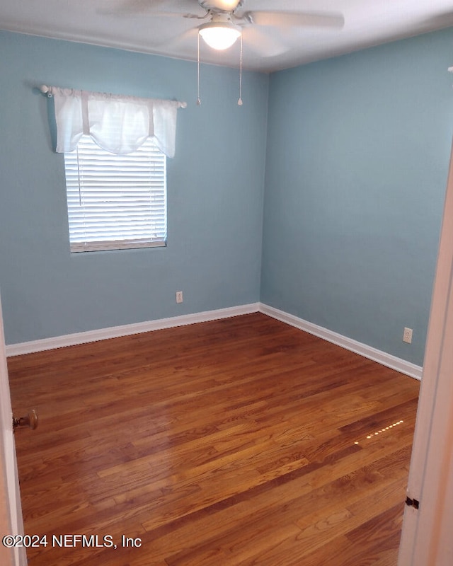 unfurnished room with dark wood finished floors, baseboards, and ceiling fan