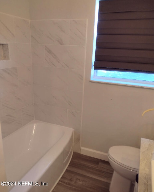 full bathroom featuring baseboards, toilet, and wood finished floors