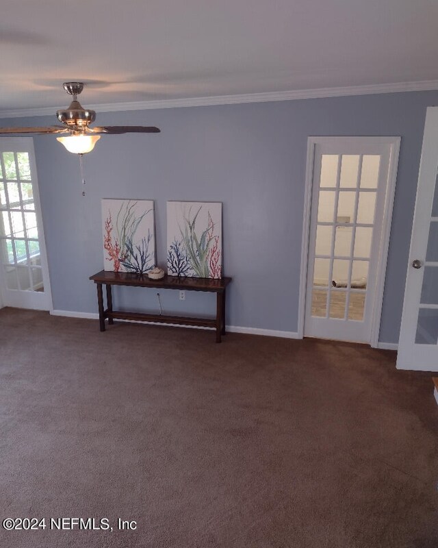 spare room featuring carpet flooring, crown molding, and baseboards