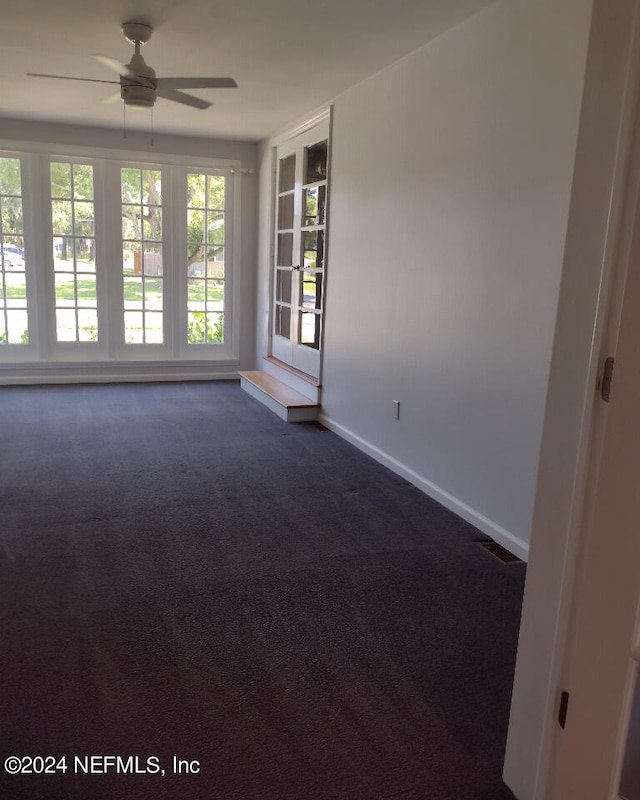 empty room featuring ceiling fan, visible vents, baseboards, and carpet flooring