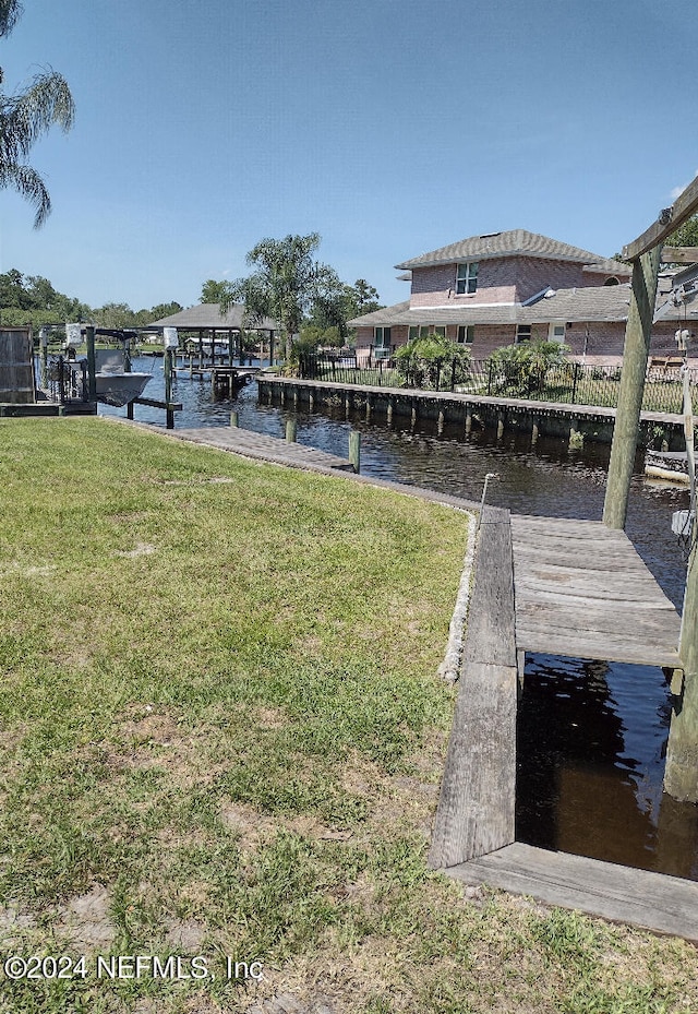 dock area with a yard and a water view