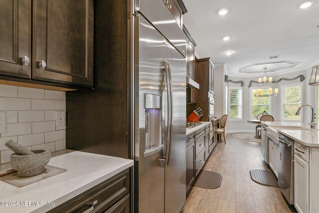 63 Stone Creek Cir, Saint Johns, FL 32259 - kitchen with appliances with stainless steel finishes, dark brown cabinetry, backsplash, recessed lighting, and ornamental molding