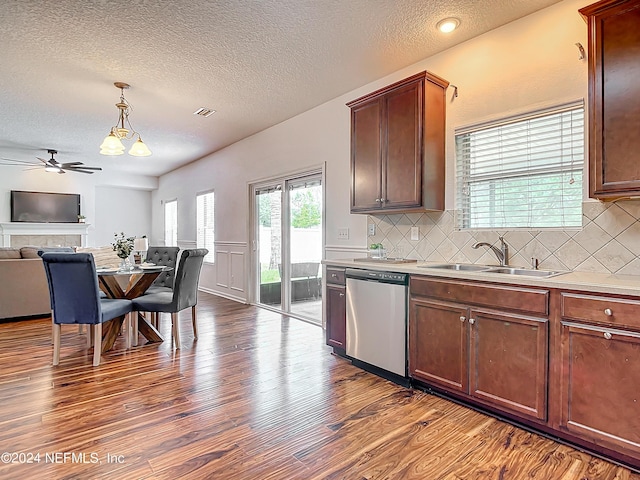 kitchen featuring ceiling fan, sink, stainless steel dishwasher, backsplash, and pendant lighting