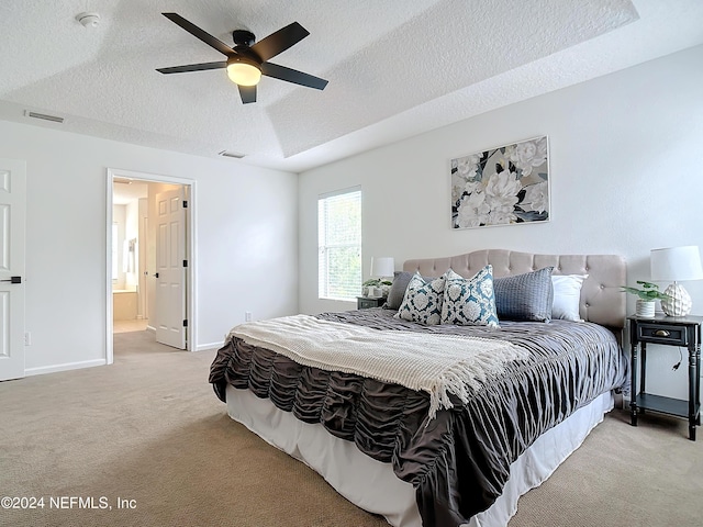 bedroom with light carpet, a textured ceiling, connected bathroom, and ceiling fan