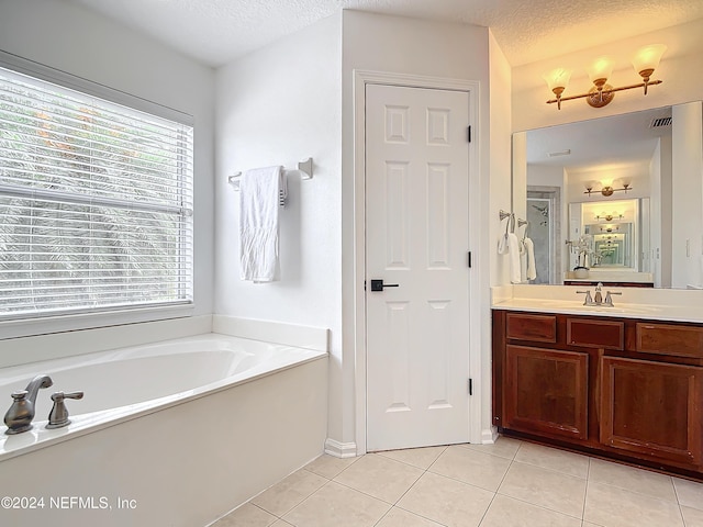 bathroom featuring tile patterned floors, vanity, shower with separate bathtub, and a textured ceiling