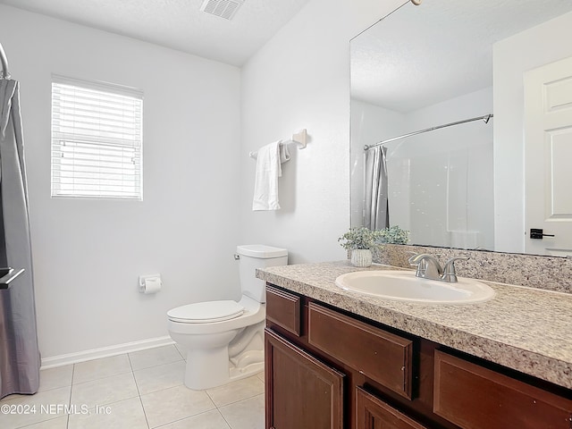 bathroom featuring curtained shower, tile patterned flooring, vanity, and toilet