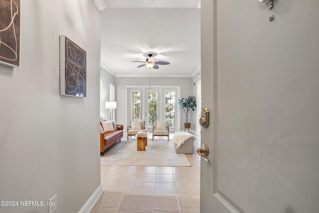 interior space with ceiling fan, ornamental molding, light tile patterned floors, and a textured ceiling