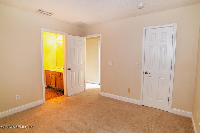 unfurnished bedroom with light carpet, visible vents, and baseboards