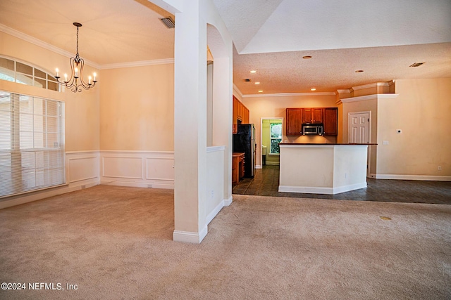 kitchen featuring dark countertops, ornamental molding, stainless steel microwave, and dark carpet