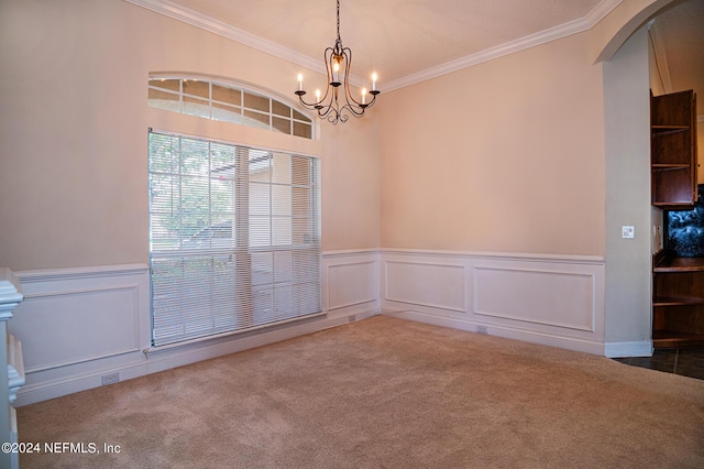 carpeted spare room with arched walkways, a wainscoted wall, a notable chandelier, and crown molding