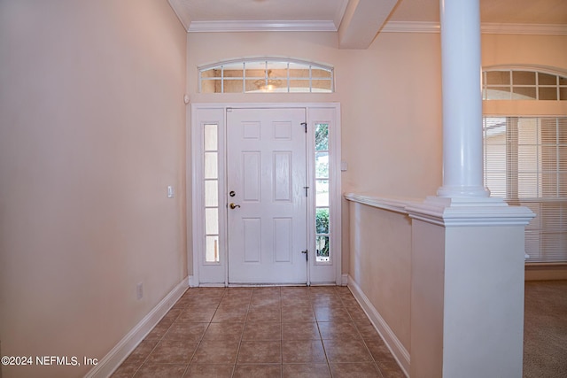 foyer featuring ornate columns, tile patterned flooring, baseboards, and crown molding