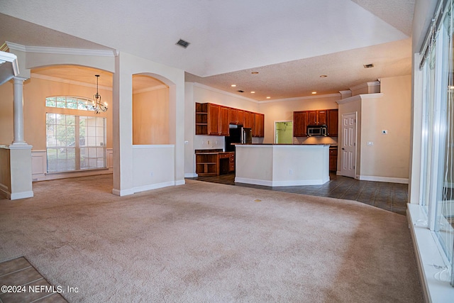 unfurnished living room with dark colored carpet, visible vents, and arched walkways