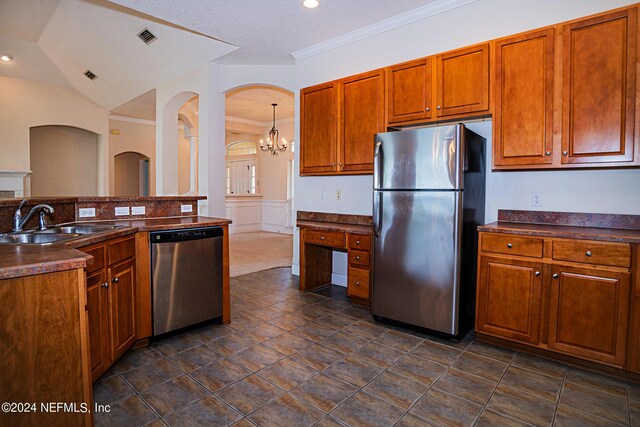 kitchen with lofted ceiling, a notable chandelier, stainless steel appliances, dark tile patterned flooring, and sink