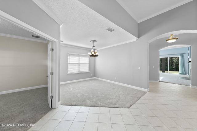 carpeted empty room with a healthy amount of sunlight, ornamental molding, a textured ceiling, and a chandelier