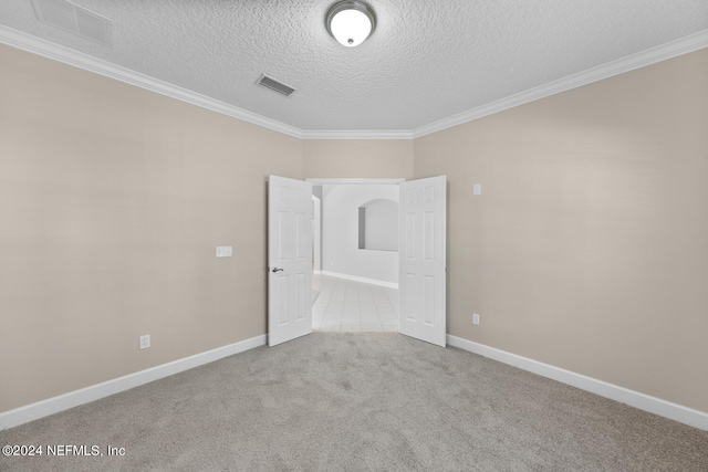 carpeted empty room with a textured ceiling and crown molding