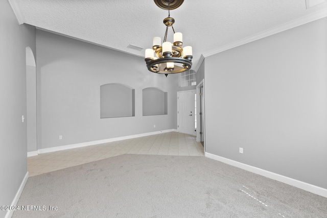 carpeted empty room featuring a notable chandelier, crown molding, and a textured ceiling