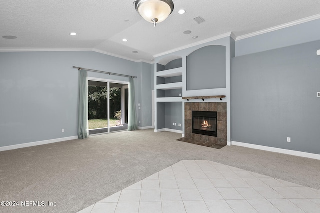 unfurnished living room featuring built in shelves, a textured ceiling, light colored carpet, a tile fireplace, and lofted ceiling