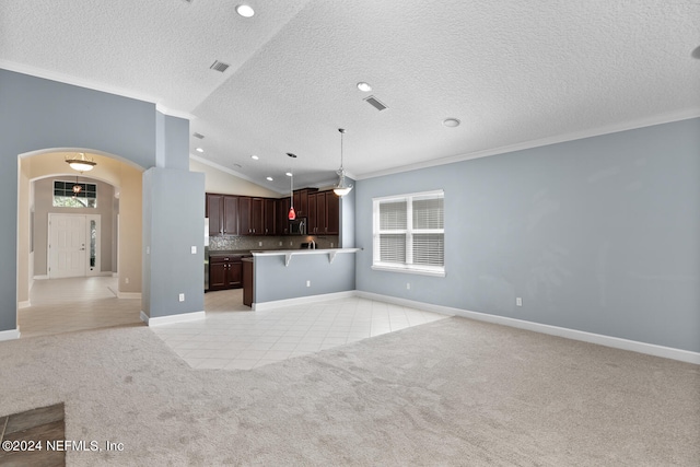 kitchen featuring a breakfast bar, crown molding, decorative backsplash, decorative light fixtures, and light colored carpet