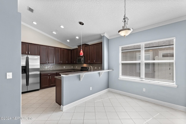 kitchen featuring kitchen peninsula, decorative light fixtures, lofted ceiling, decorative backsplash, and appliances with stainless steel finishes