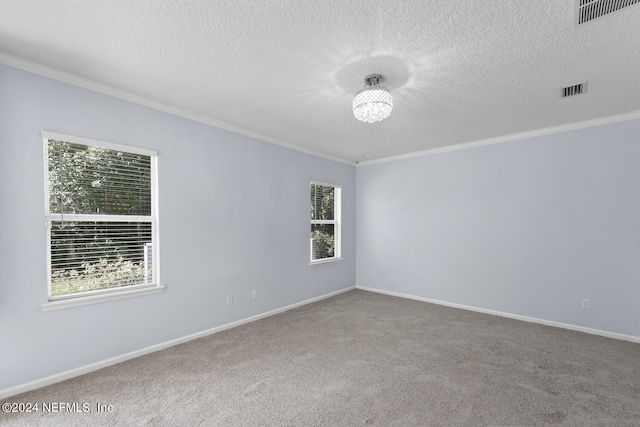 carpeted empty room featuring a notable chandelier, ornamental molding, and a textured ceiling