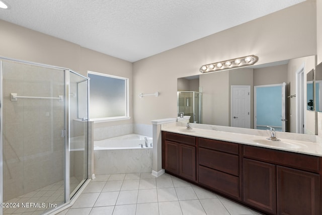 bathroom with tile patterned floors, vanity, independent shower and bath, and a textured ceiling