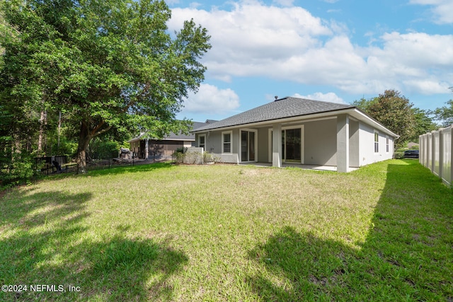 back of property featuring a yard